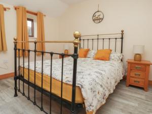 a bedroom with a black bed with orange pillows at Honeybee Cottage in Hull