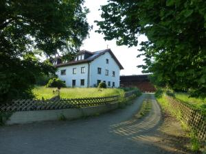a white house on a hill with a fence at Moorwiesenhof in Ostrach