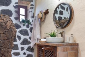 a bathroom with a sink and a mirror on the wall at El Rincón de Guatisea in San Bartolomé +26 photos