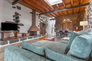 a living room with a blue couch and a fireplace at El Rincón de Guatisea in San Bartolomé