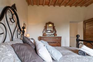 a bedroom with a bed with a mirror and a dresser at Casa Biffoli - Bucine in Bucine +21 photos