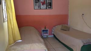 a room with two beds and a small table in it at Kitinete e suite Recanto do Bem-te-vi in Serra