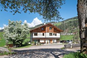 a large house with a tree in front of it at Baumannhof Villnöß in Funes