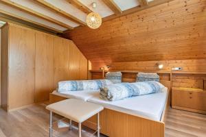 a bedroom with two beds in a wooden room at Gästehaus Gerda in Bad Peterstal-Griesbach