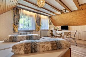 two beds in a room with a table and chairs at Gästehaus Gerda in Bad Peterstal-Griesbach