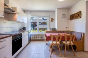 a kitchen with a table and chairs and a dining room at Haus Isele in Urberg