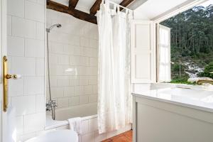 a bathroom with a shower and a sink and a window at La Braña in Bustio +22 photos