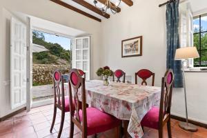 a dining room with a table with pink chairs at La Braña in Bustio