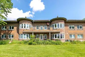 a large brick building with a grass field in front of it at Amrum in Galmsbüll