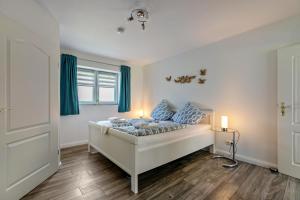 a bedroom with a bed with blue curtains at Amrum in Galmsbüll
