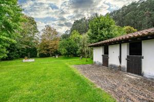 a house with a grass yard next to a building at La Braña in Bustio