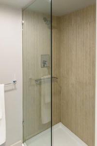 a shower with a glass door in a bathroom at Downtown Historic Nantucket Cottage in Nantucket +2 photos