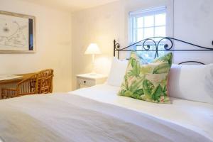 a bedroom with a bed and a table and a window at Downtown Historic Nantucket Cottage in Nantucket