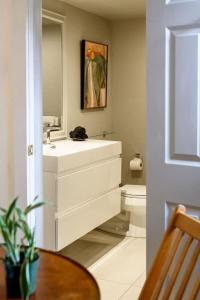 a white bathroom with a sink and a toilet at Downtown Historic Nantucket Cottage in Nantucket
