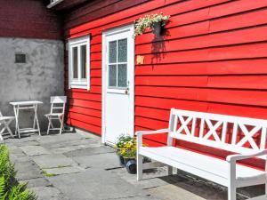 a red house with a white bench in front of it at Apartment Floren by Interhome in Herand