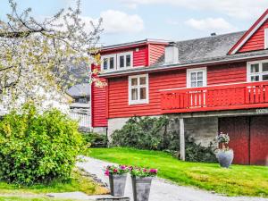 a red house with flowers in front of it at Apartment Floren by Interhome in Herand