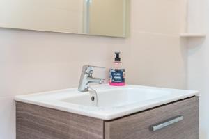 a bathroom sink with a soap bottle on it at Casa La Mar in Santanyi +12 photos