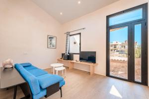 a living room with a blue couch and a tv at Casa La Mar in Santanyi