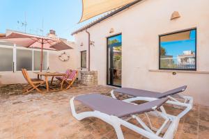 a patio with a table and chairs and an umbrella at Casa La Mar in Santanyi