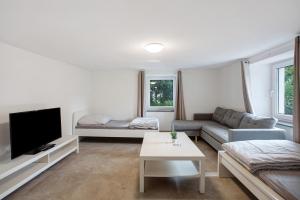 a living room with a couch and a tv at Ferienapartments Ariana in Bad Säckingen