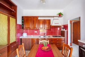 a kitchen with a wooden table with a red table cloth at Villa Lucia Guesthouse Minturno in Minturno