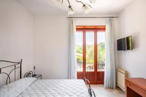 a bedroom with a bed and a sliding glass door at Villa Lucia Guesthouse Minturno in Minturno