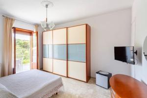 a bedroom with a bed and a tv on a wall at Villa Lucia Guesthouse Minturno in Minturno