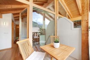 a wooden room with a wooden table and a chair at Ferienwohnungen Zwick Valarga in Malles Venosta