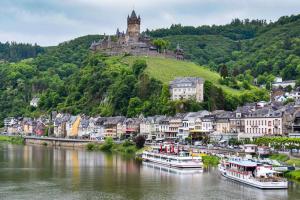 a town on a hill with boats in a river at Eifel im Herzen in Hambuch