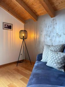 a room with a blue couch and a lamp at Ferienwohnungen Zwick Valarga in Malles Venosta