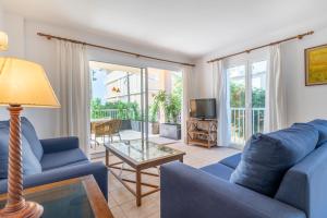 a living room with two blue couches and a table at Talaia Bajos A in Port de Pollensa