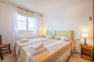 a bedroom with a large bed with towels on it at Talaia Bajos A in Port de Pollensa