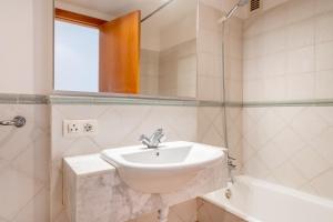 a bathroom with a sink and a mirror and a tub at Talaia Bajos A in Port de Pollensa +17 photos