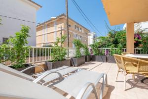 a balcony with tables and chairs and a building at Talaia Bajos A in Port de Pollensa