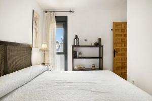 a bedroom with a white bed and a window at Bella Vistas in Zahara de los Atunes +21 photos