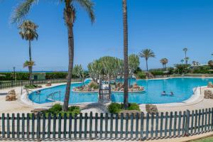 a swimming pool at a resort with palm trees at Bella Vistas in Zahara de los Atunes