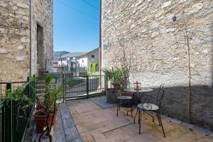 a patio with a table and chairs and plants at Prima Del Cielo -Appartamento Monti in Esino Lario
