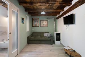 a living room with a couch and a flat screen tv at Prima Del Cielo -Appartamento Monti in Esino Lario