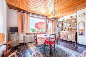 a dining room with a table with chairs and an umbrella at Apt Morzine 1000 in Morzine