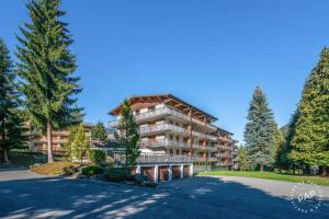 a large apartment building with trees in front of it at Apt Morzine 1000 in Morzine
