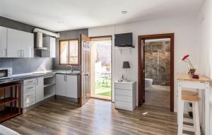 a kitchen with white cabinets and a wooden floor at Casa Magui in Capdepera