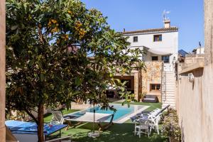 an orange tree in the yard of a house with a swimming pool at Casa Magui in Capdepera