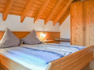 a large bed in a room with a wooden ceiling at Stulzenhof in Hofstetten