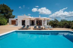 a villa with a swimming pool in front of a house at Can Joan Durban in Sant Joan de Labritja