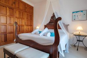 a bedroom with a wooden bed with a canopy at Can Joan Durban in Sant Joan de Labritja +34 photos
