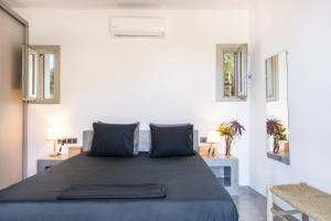 a bedroom with a large bed with two windows at Black Tower Villa in Apollonia