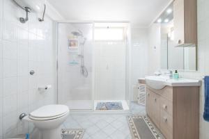 a bathroom with a toilet and a shower and a sink at Casa Vacanze 4 Venti in Muravera +16 photos
