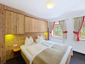 a bedroom with a bed with a wooden headboard at Apartment Naviser Hütte-3 by Interhome in Navis