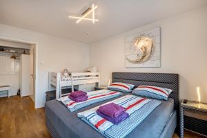 a bedroom with a bed with purple pillows on it at Ferienwohnung Moin am Meer in Scharbeutz