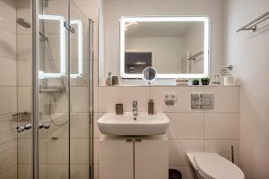 a white bathroom with a sink and a mirror at Ferienwohnung Moin am Meer in Scharbeutz +15 photos